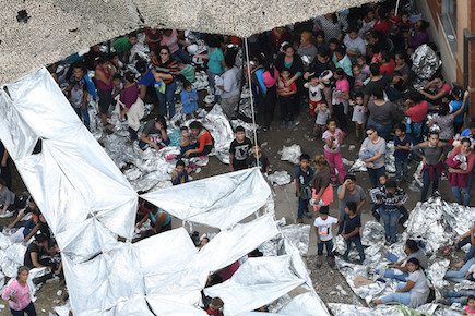 Migrants are seen outside the U.S. Border Patrol McAllen Station in a makeshift encampment in McAllen